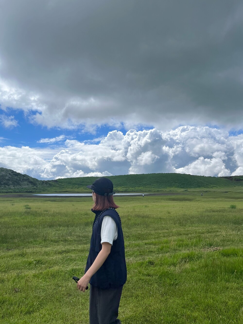 ブルー系のベスト、ブラック系のスニーカー、ブラック系のキャップを着用したレディースの夏コーディネートの3枚目の写真