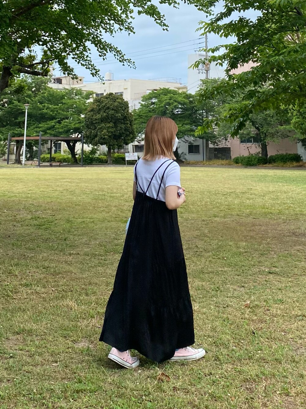 ブラック系のワンピース、ブルー系のエコバッグ/サブバッグ、ピンク系のスニーカーを着用したレディースの春コーディネートの2枚目の写真