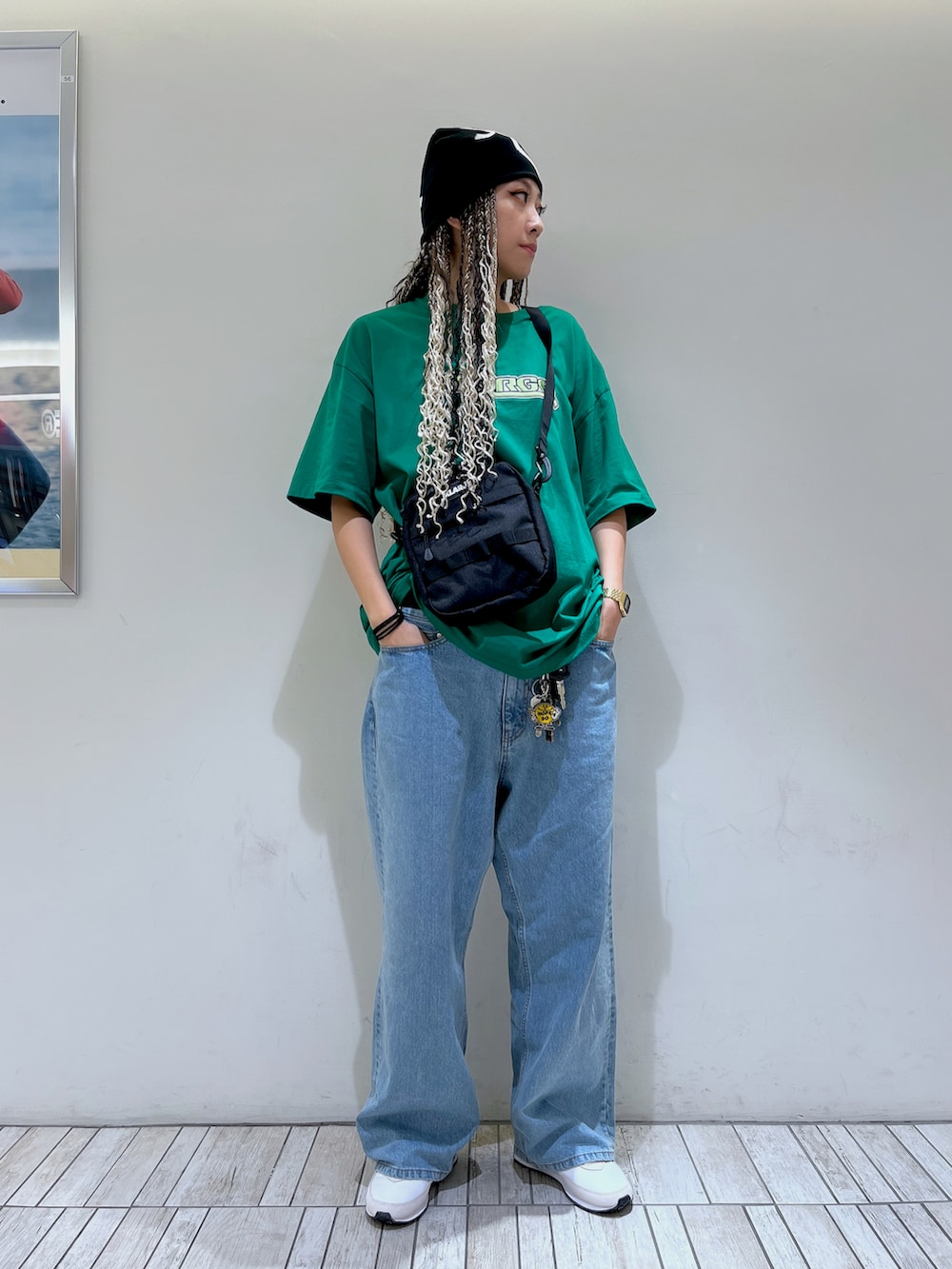 グリーン系のTシャツ/カットソー、ブルー系のデニムパンツ、ブラック系のニットキャップ/ビーニーを着用したレディースの春コーディネートの2枚目の写真