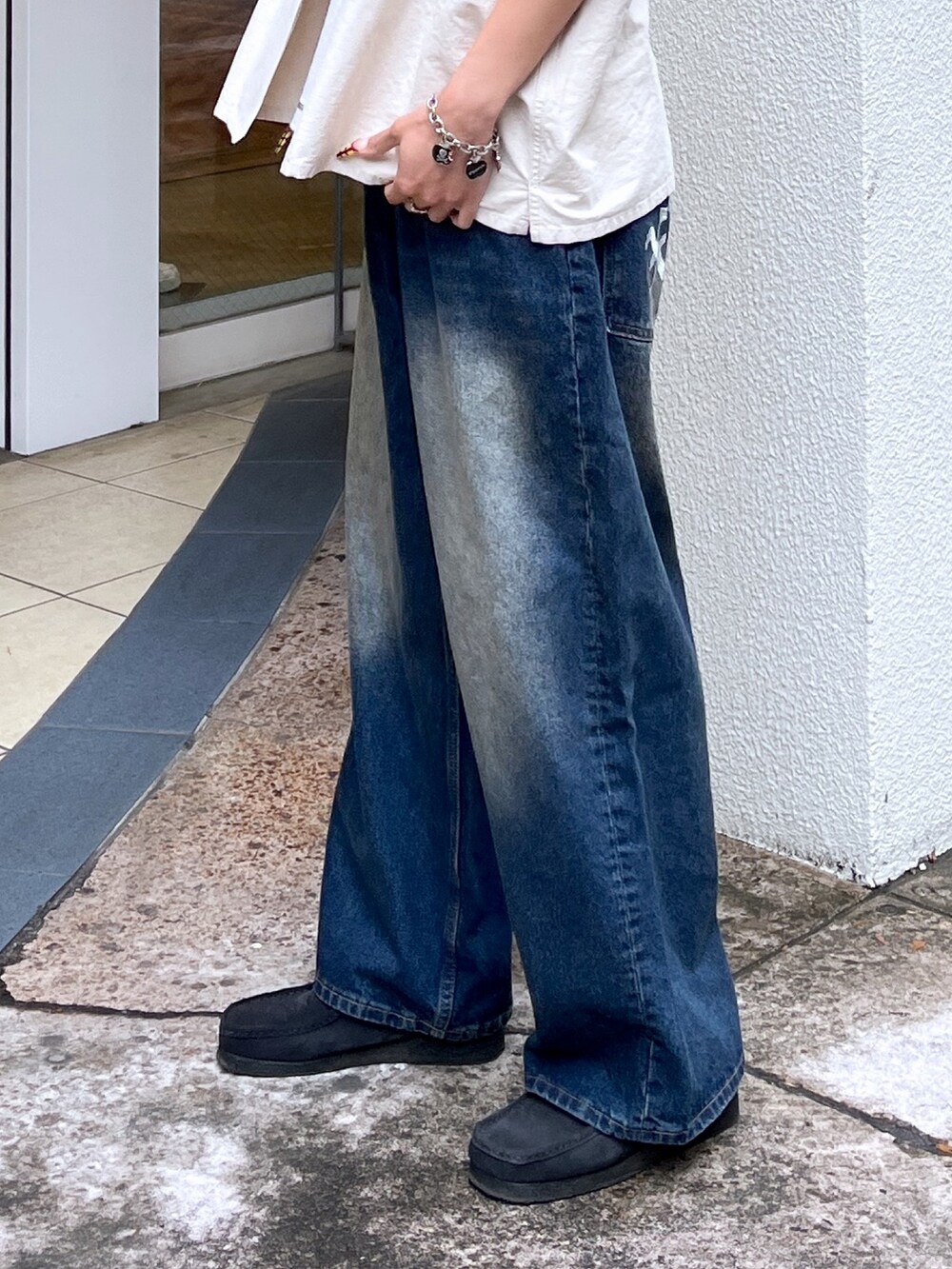 ベージュ系のシャツ/ブラウス、ブルー系のデニムパンツ、ブラック系のスニーカーを着用したレディースの春コーディネートの3枚目の写真