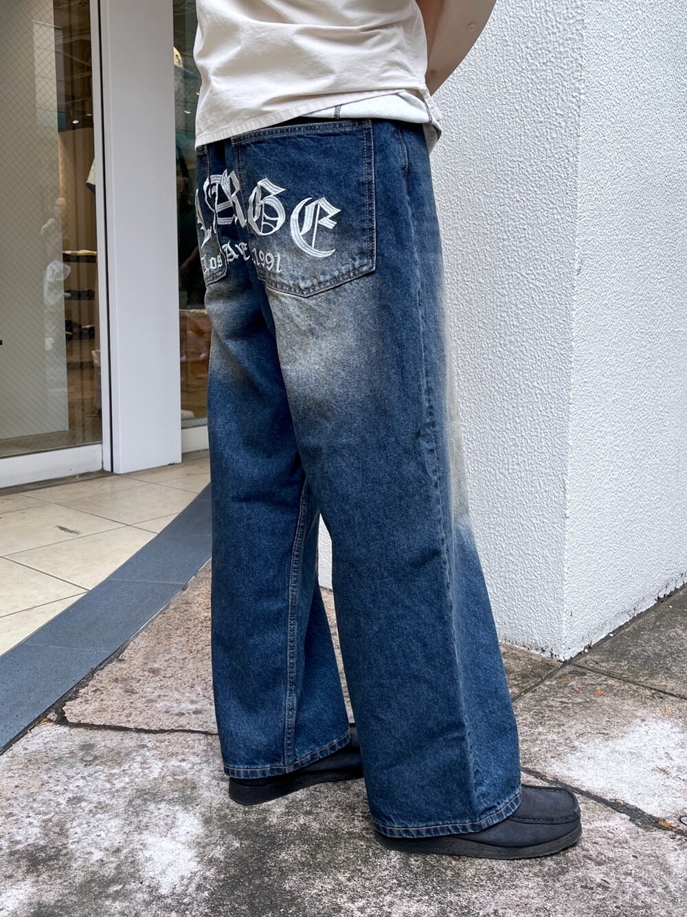 ベージュ系のシャツ/ブラウス、ブルー系のデニムパンツ、ブラック系のスニーカーを着用したレディースの春コーディネートの4枚目の写真