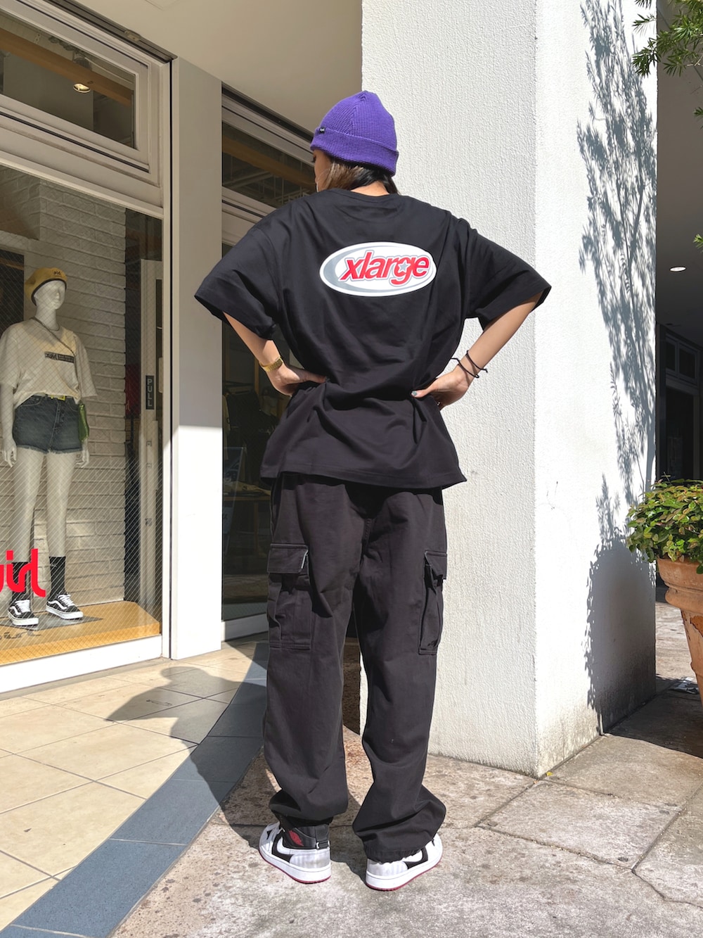 ブラック系のTシャツ/カットソー、ブラック系のその他パンツ、パープル系のニットキャップ/ビーニーを着用したレディースの春コーディネートの2枚目の写真