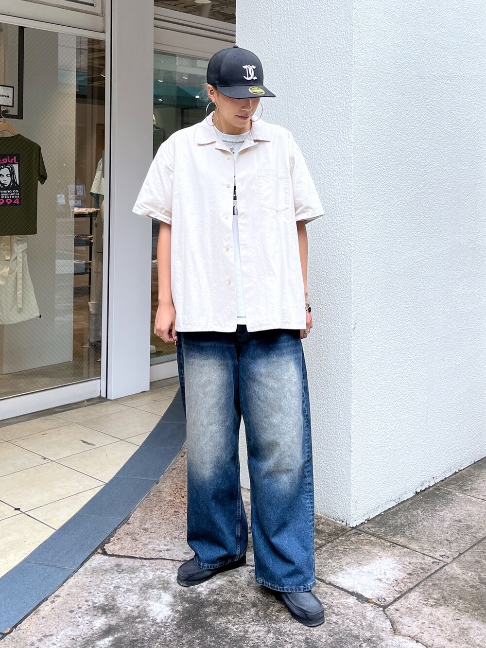 ベージュ系のシャツ/ブラウス、ブルー系のデニムパンツ、ブラック系のスニーカーを着用したレディースの春コーディネートの2枚目の写真