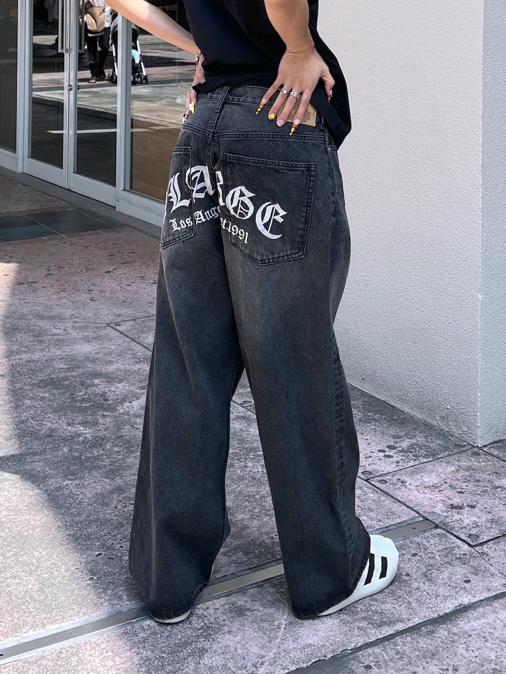 ブラック系のTシャツ/カットソー、ブラック系のデニムパンツ、ブラック系のサングラスを着用したレディースの春コーディネートの2枚目の写真