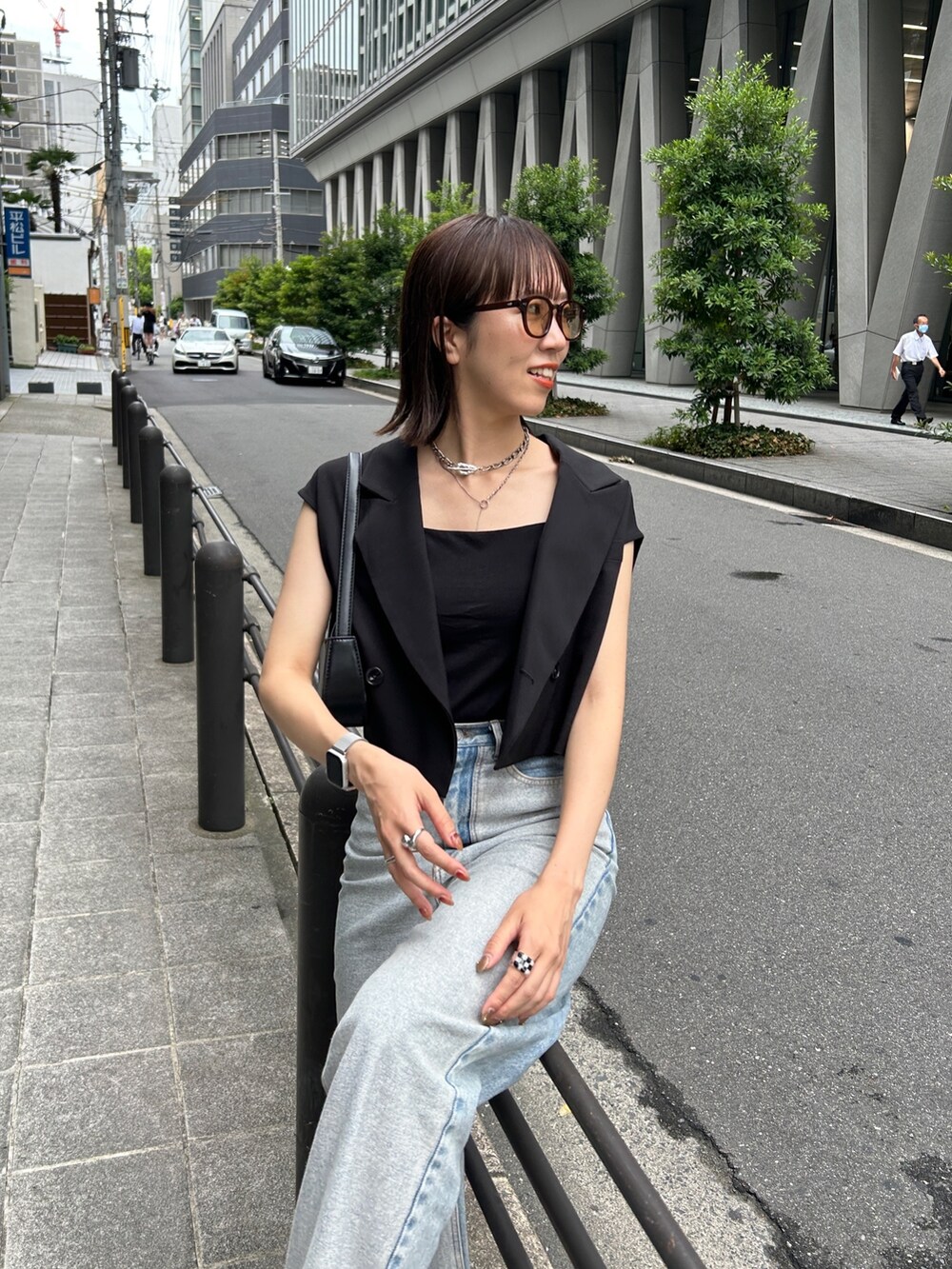ブラック系のベスト、ブラック系のローファー、ブルー系のデニムパンツを着用したレディースの夏コーディネートの2枚目の写真