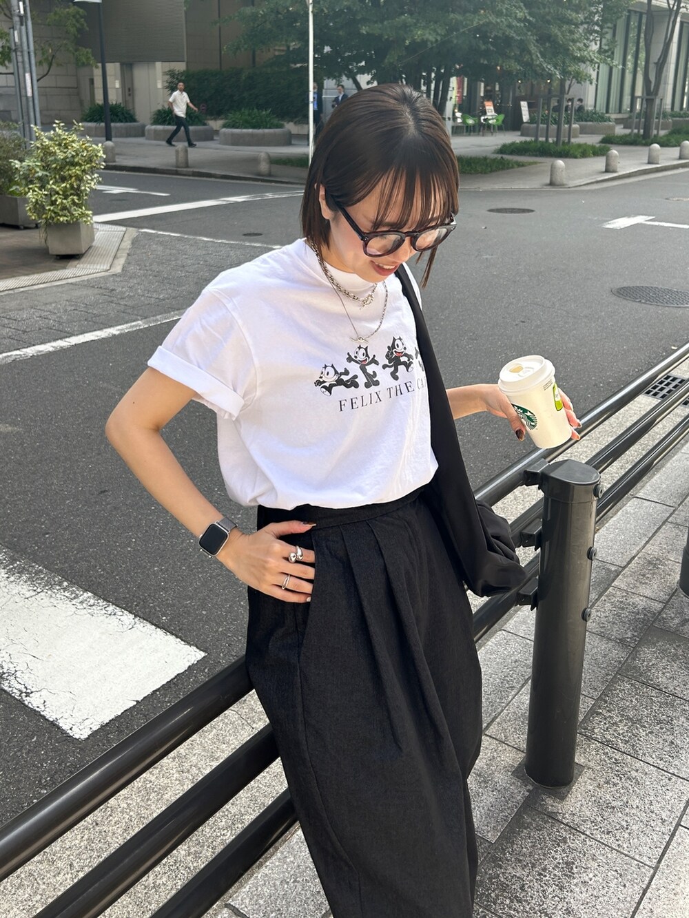ブラック系のパンツ、ホワイト系のTシャツ/カットソー、ブラック系のバッグを着用したレディースの春コーディネートの2枚目の写真