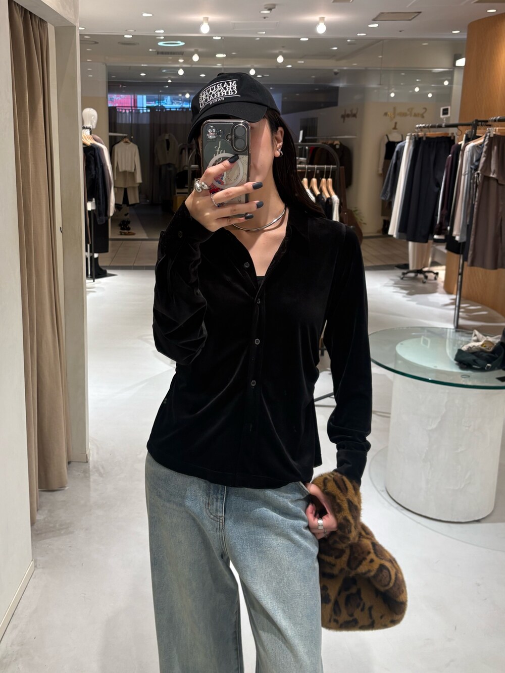 ブラック系のシャツ/ブラウス、ブルー系のデニムパンツ、ブラウン系のハンドバッグを着用したレディースの秋コーディネートの2枚目の写真