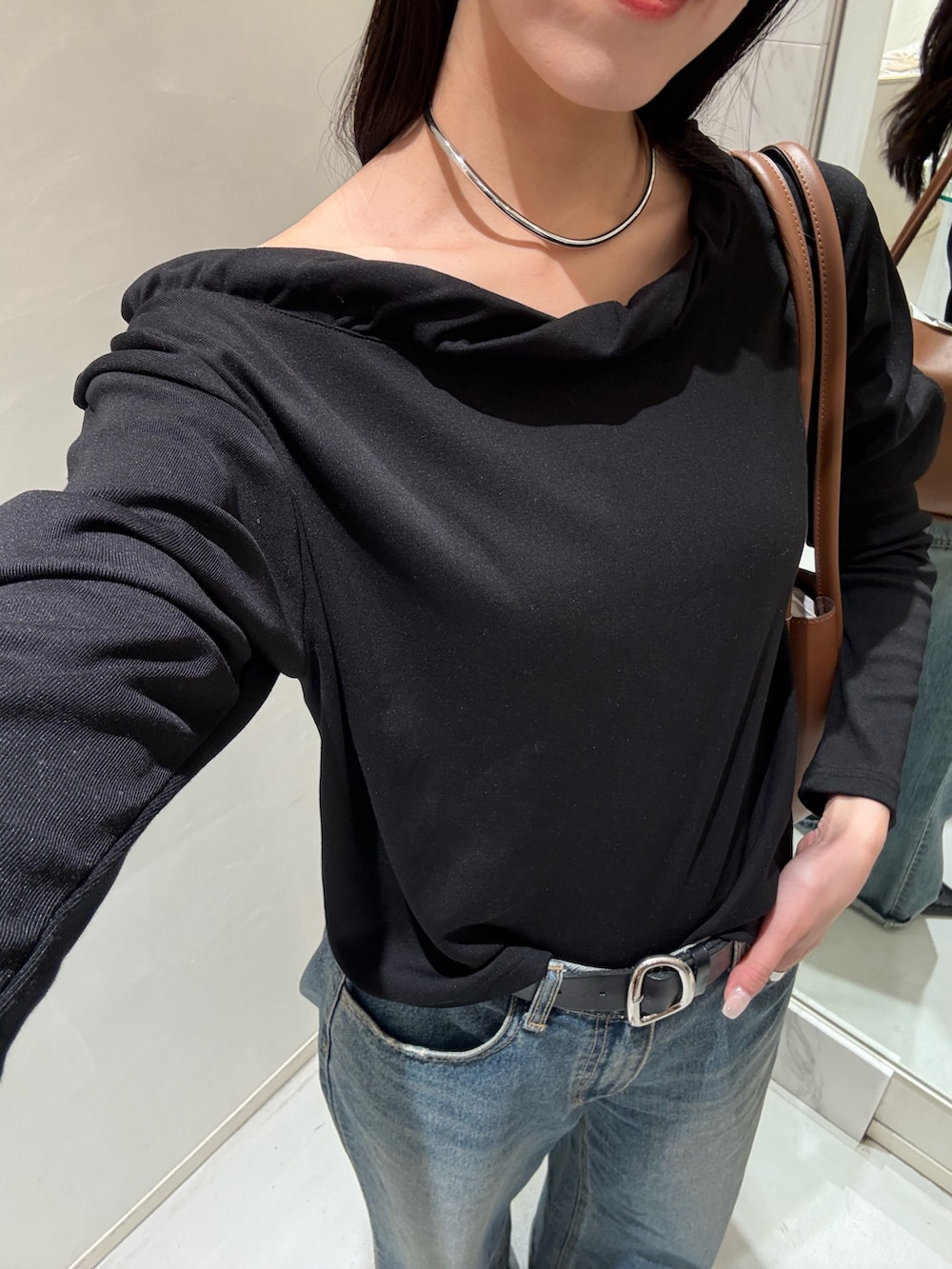 ブルー系のデニムパンツ、ブラック系のTシャツ/カットソー、ブラウン系のショルダーバッグを着用したレディースの春コーディネートの2枚目の写真