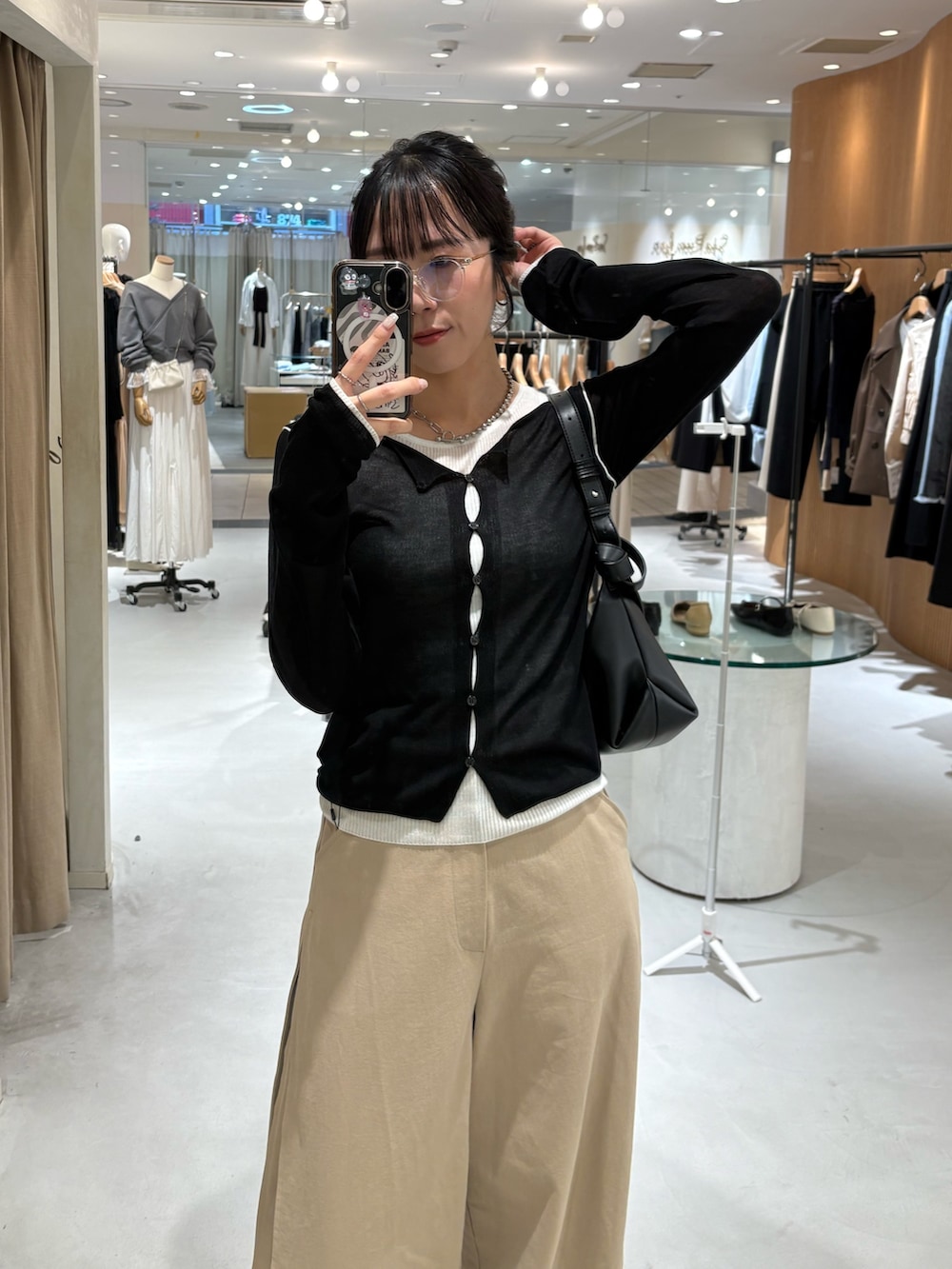 ベージュ系のその他パンツ、ブラック系のカーディガン/ボレロ、ブラック系のショルダーバッグを着用したレディースの春コーディネートの2枚目の写真