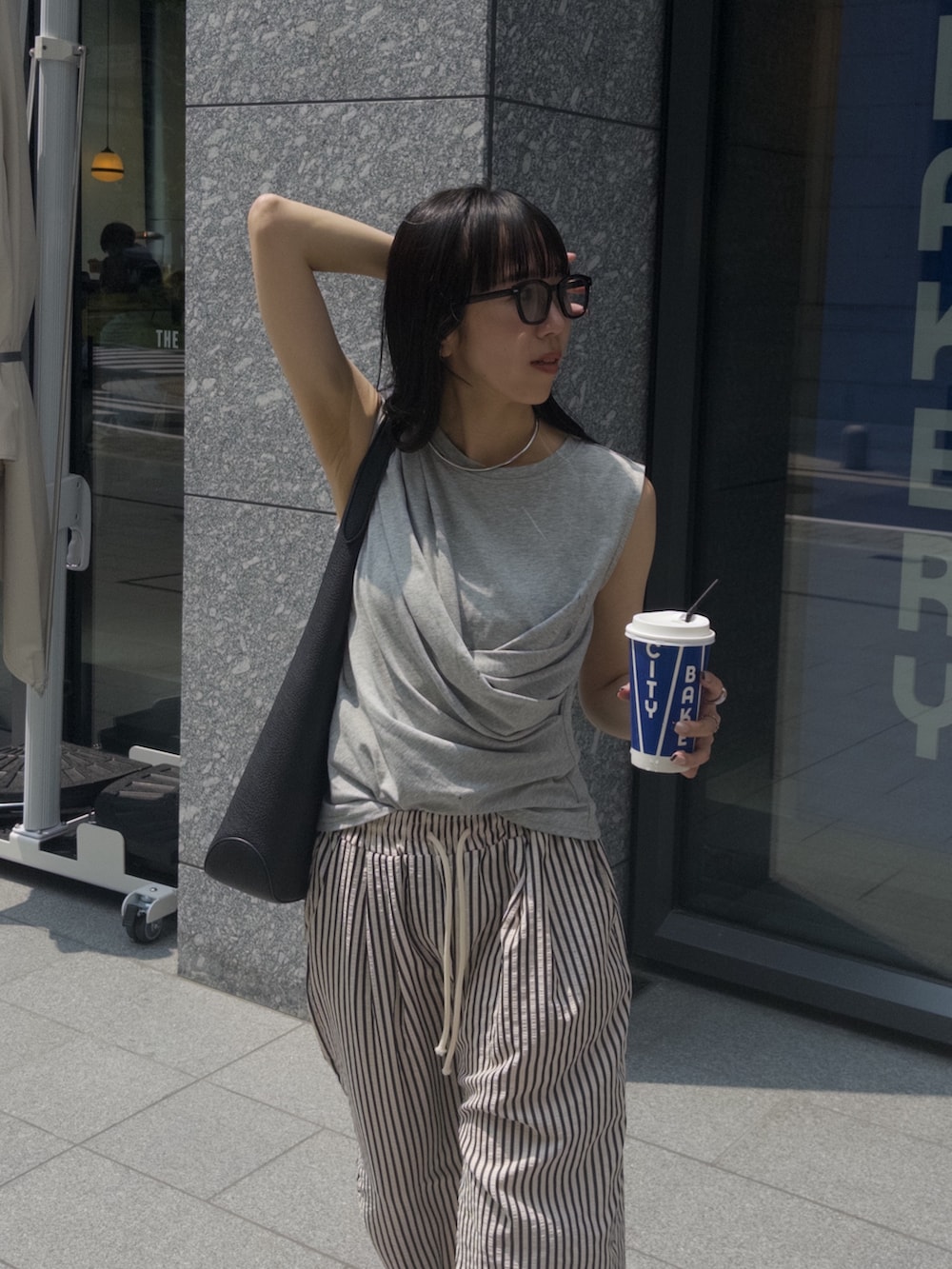 ホワイト系のその他パンツ、グレー系のTシャツ/カットソー、ブラック系のトートバッグを着用したレディースの夏コーディネートの2枚目の写真