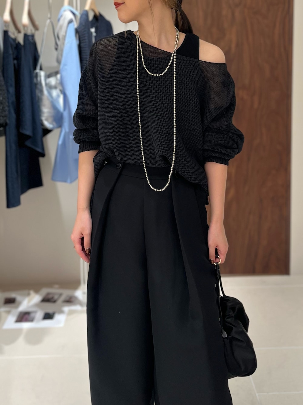 ブラック系のニット/セーター、ブラック系のその他パンツ、ブラック系のトートバッグを着用したレディースの春コーディネートの2枚目の写真