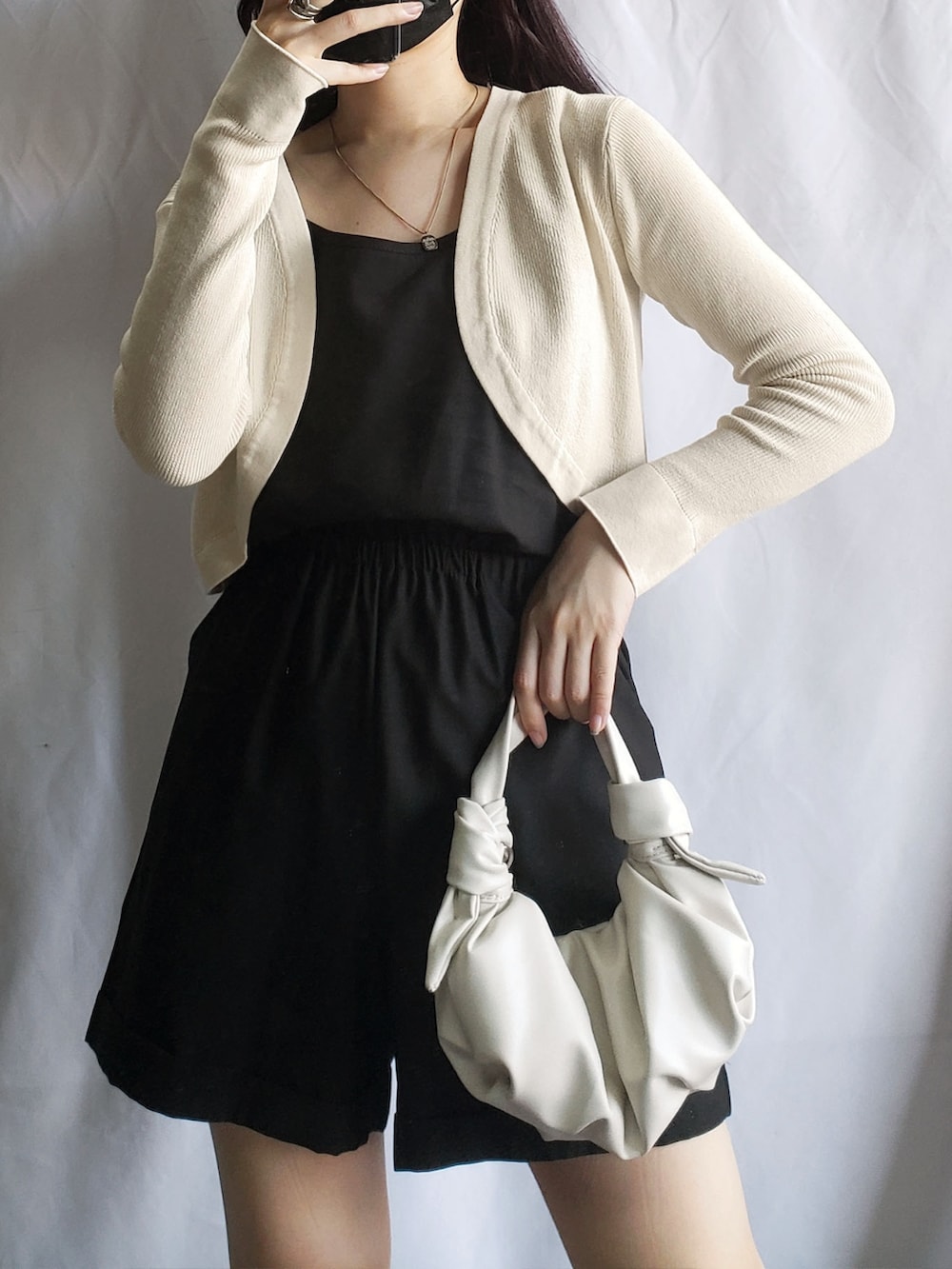 グリーン系のカーディガン/ボレロ、ホワイト系のスラックスを着用したレディースの夏コーディネートの2枚目の写真