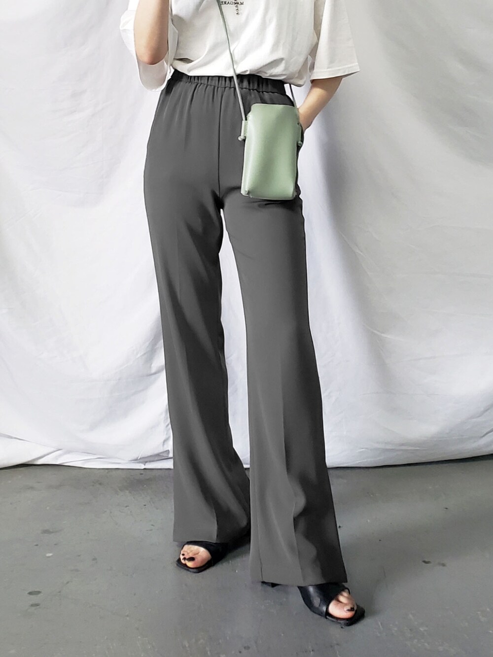 グリーン系のシャツ/ブラウス、グリーン系のハンドバッグ、ホワイト系のスラックスを着用したレディースの春コーディネートの3枚目の写真