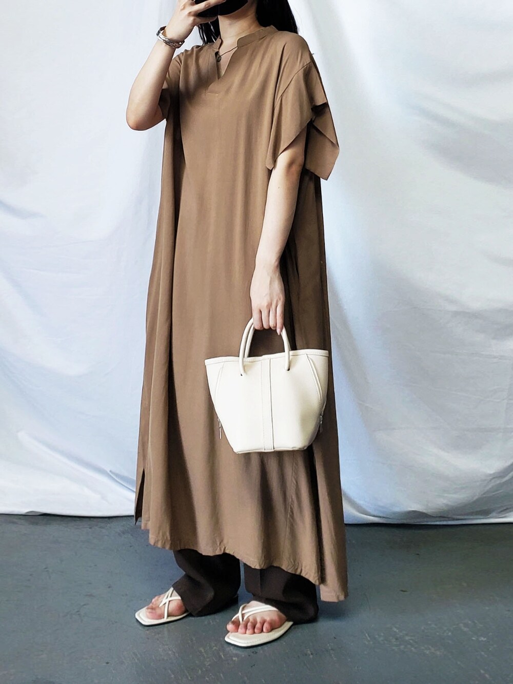 グリーン系のワンピース、ブラック系のサンダルを着用したレディースの夏コーディネートの2枚目の写真