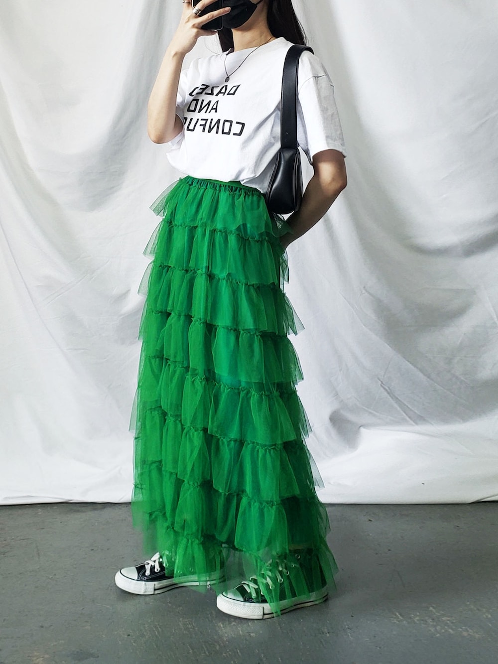 ホワイト系のTシャツ/カットソー、オレンジ系のスカート、ブラック系のショルダーバッグを着用したレディースの春コーディネートの2枚目の写真