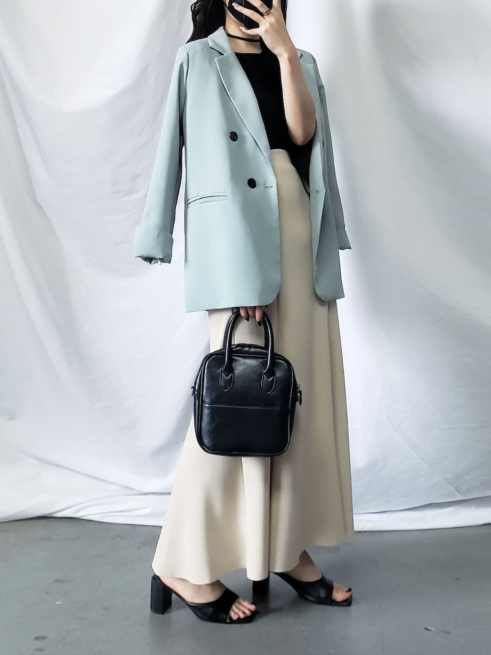 ピンク系のスラックス、ホワイト系のテーラードジャケットを着用したレディースの春コーディネートの2枚目の写真