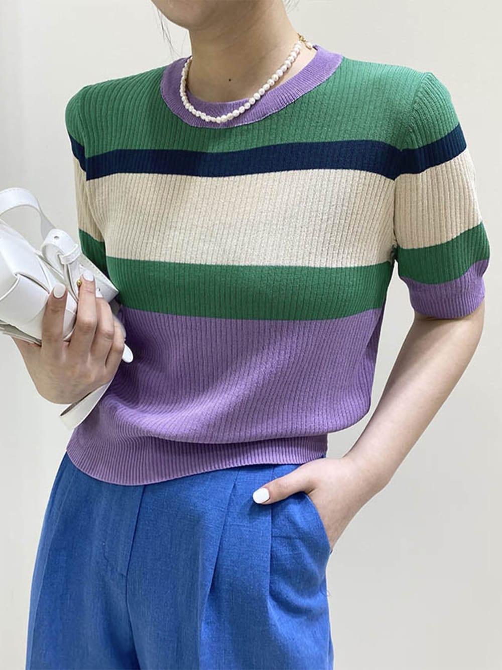 ブルー系のニット/セーターを着用したレディースの夏コーディネートの2枚目の写真