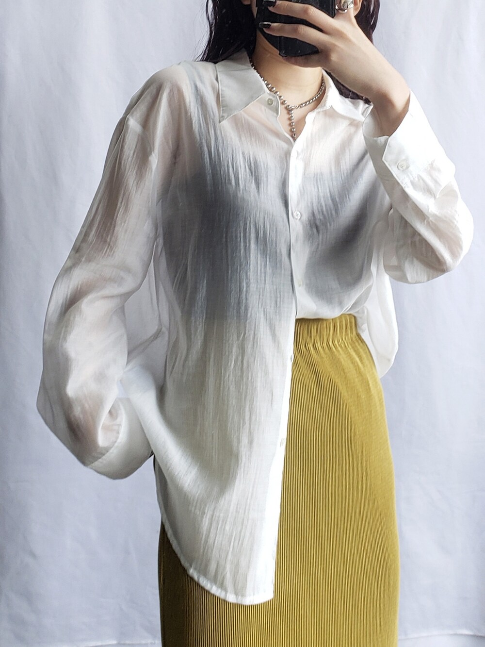 ホワイト系のスラックス、グリーン系のシャツ/ブラウス、ブラック系のサンダルを着用したレディースの夏コーディネートの3枚目の写真