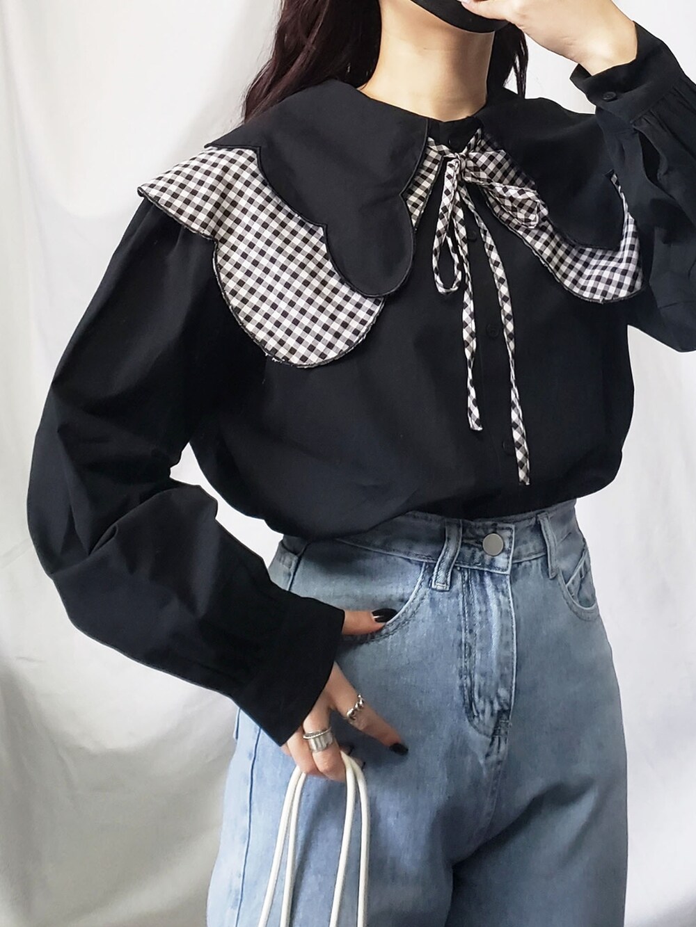 ホワイト系のデニムパンツ、ブラック系のシャツ/ブラウスを着用したレディースの春コーディネートの2枚目の写真