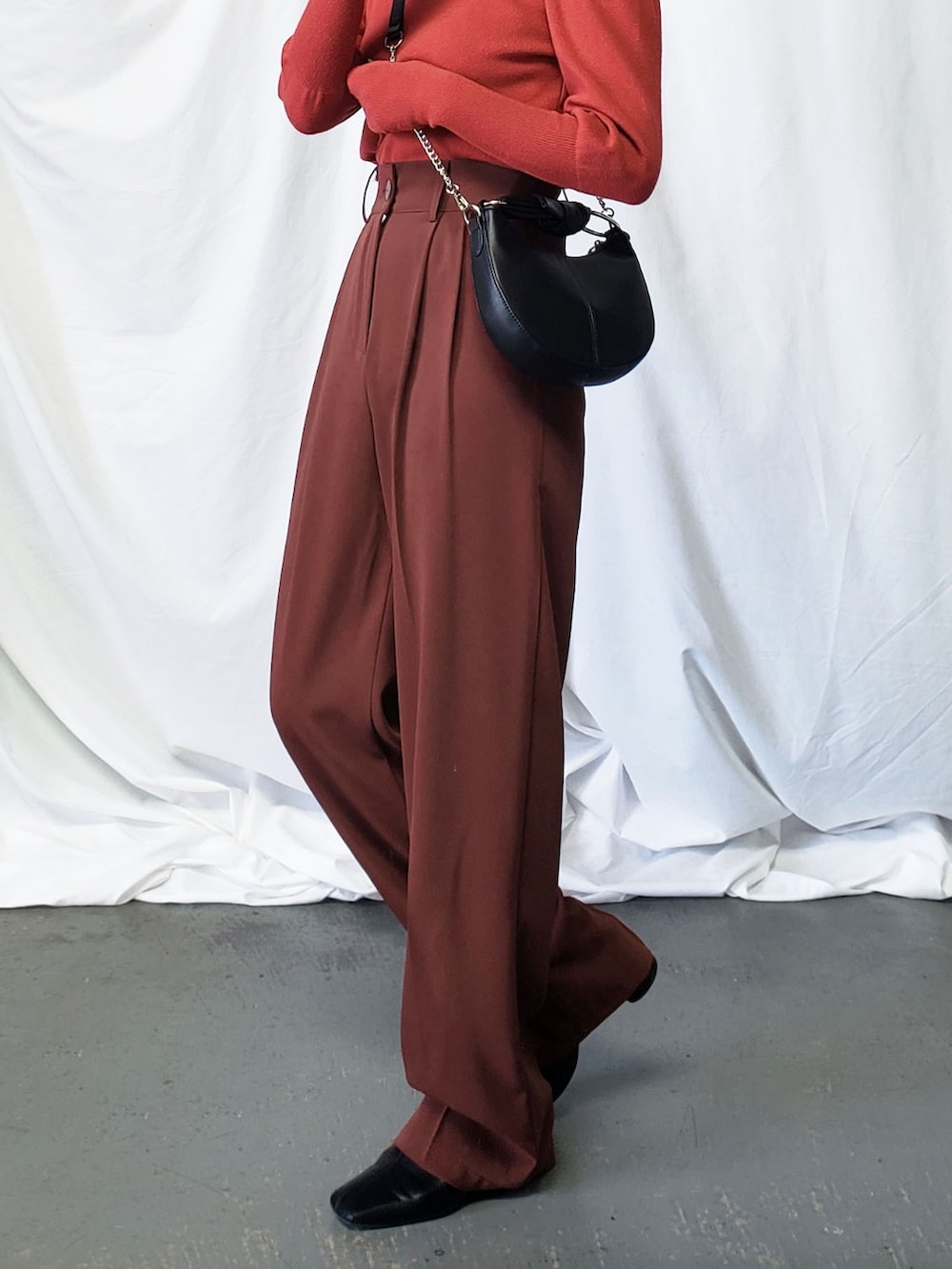 ブラック系のサンダル、グリーン系のスラックス、ブラック系のニット/セーターを着用したレディースの夏コーディネートの3枚目の写真