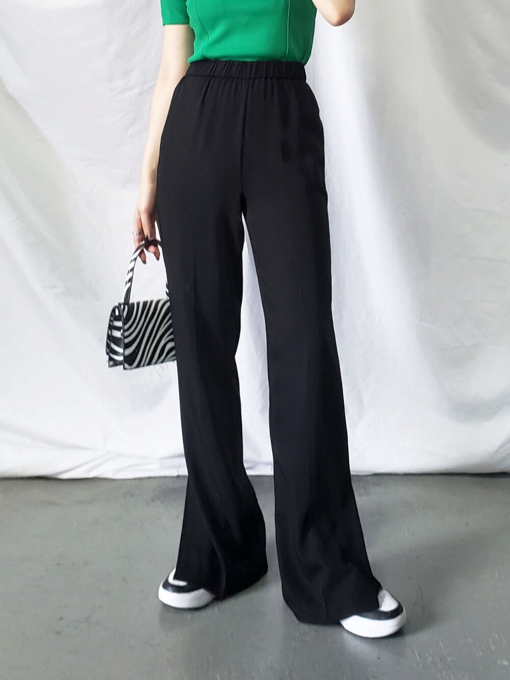 グリーン系のシャツ/ブラウス、グリーン系のハンドバッグ、ホワイト系のスラックスを着用したレディースの春コーディネートの4枚目の写真