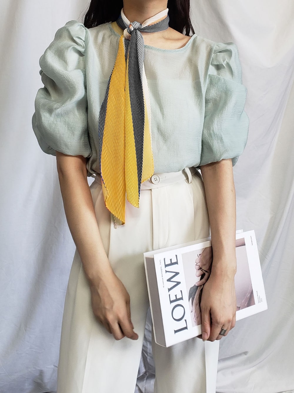 ベージュ系のシャツ/ブラウス、オレンジ系のバンダナ/スカーフを着用したレディースの夏コーディネートの2枚目の写真