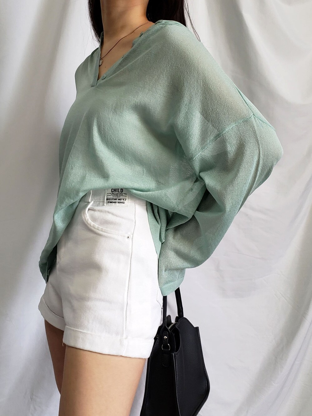 ブラック系のTシャツ/カットソー、イエロー系のその他パンツ、ブラック系のショルダーバッグを着用したレディースの春コーディネートの5枚目の写真