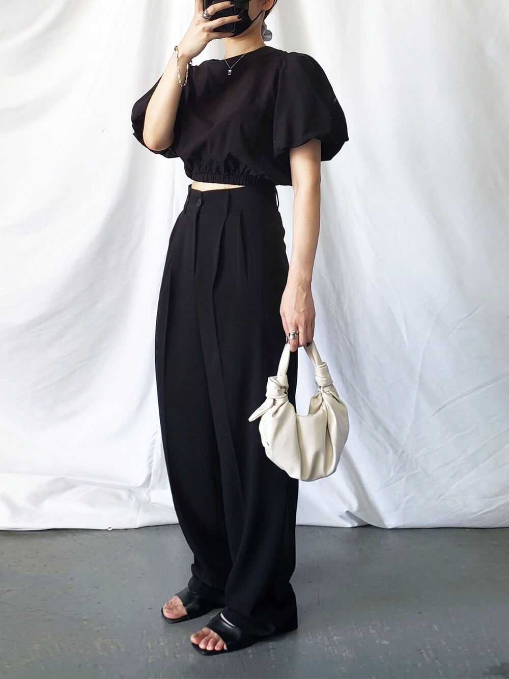 ブラック系のスカート、ベージュ系のシャツ/ブラウスを着用したレディースの夏コーディネートの2枚目の写真