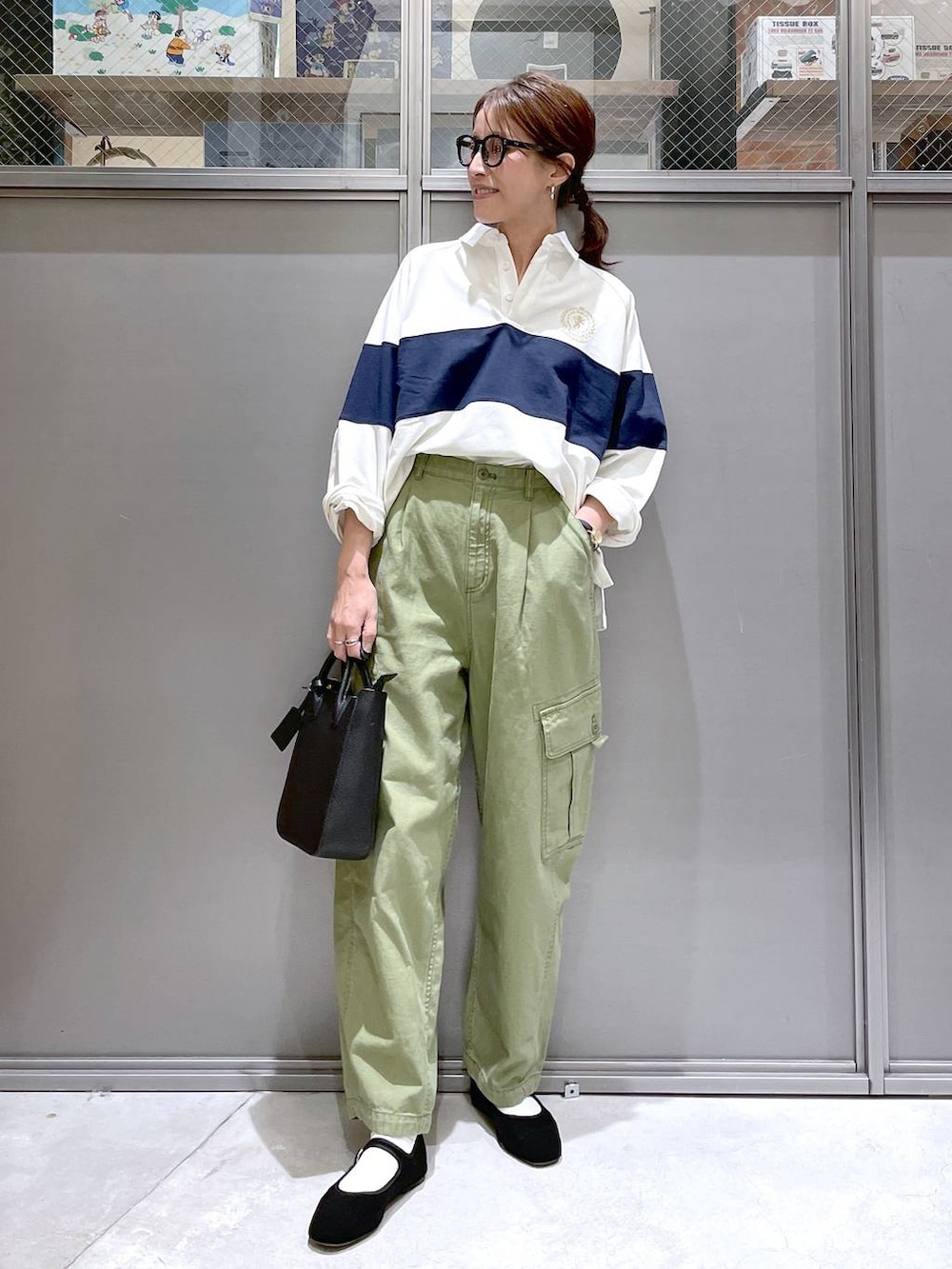 ブラック系のトートバッグ、ブラック系のパンプス、グリーン系のカーゴパンツを着用したレディースの春コーディネートの5枚目の写真