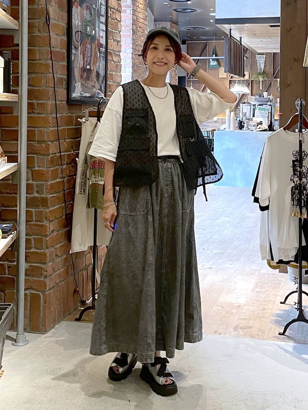 グレー系のサンダル、グレー系のスカート、ホワイト系のTシャツ/カットソーを着用したレディースの夏コーディネートの8枚目の写真