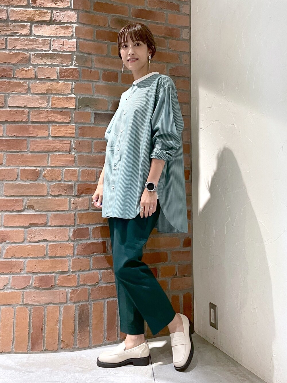 グリーン系のシャツ/ブラウス、グリーン系のその他パンツ、ベージュ系のローファーを着用したレディースの夏コーディネートの4枚目の写真