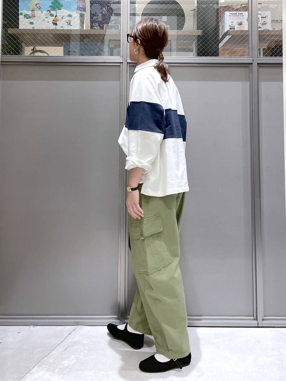 ブラック系のトートバッグ、ブラック系のパンプス、グリーン系のカーゴパンツを着用したレディースの春コーディネートの4枚目の写真