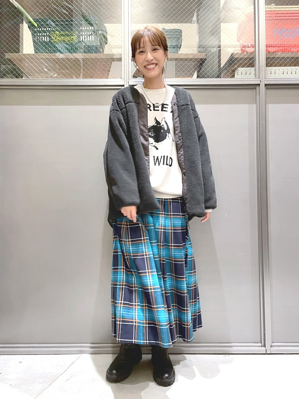 ベージュ系のニット/セーター、グレー系のブルゾン、ブルー系のスカートを着用したレディースの秋コーディネートの5枚目の写真