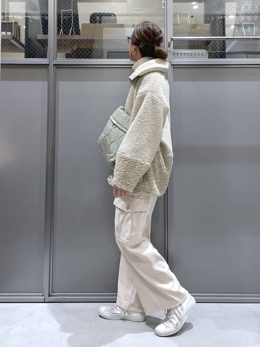 ベージュ系のその他アウター、ベージュ系のニット/セーター、グリーン系のショルダーバッグを着用したレディースの秋コーディネートの4枚目の写真