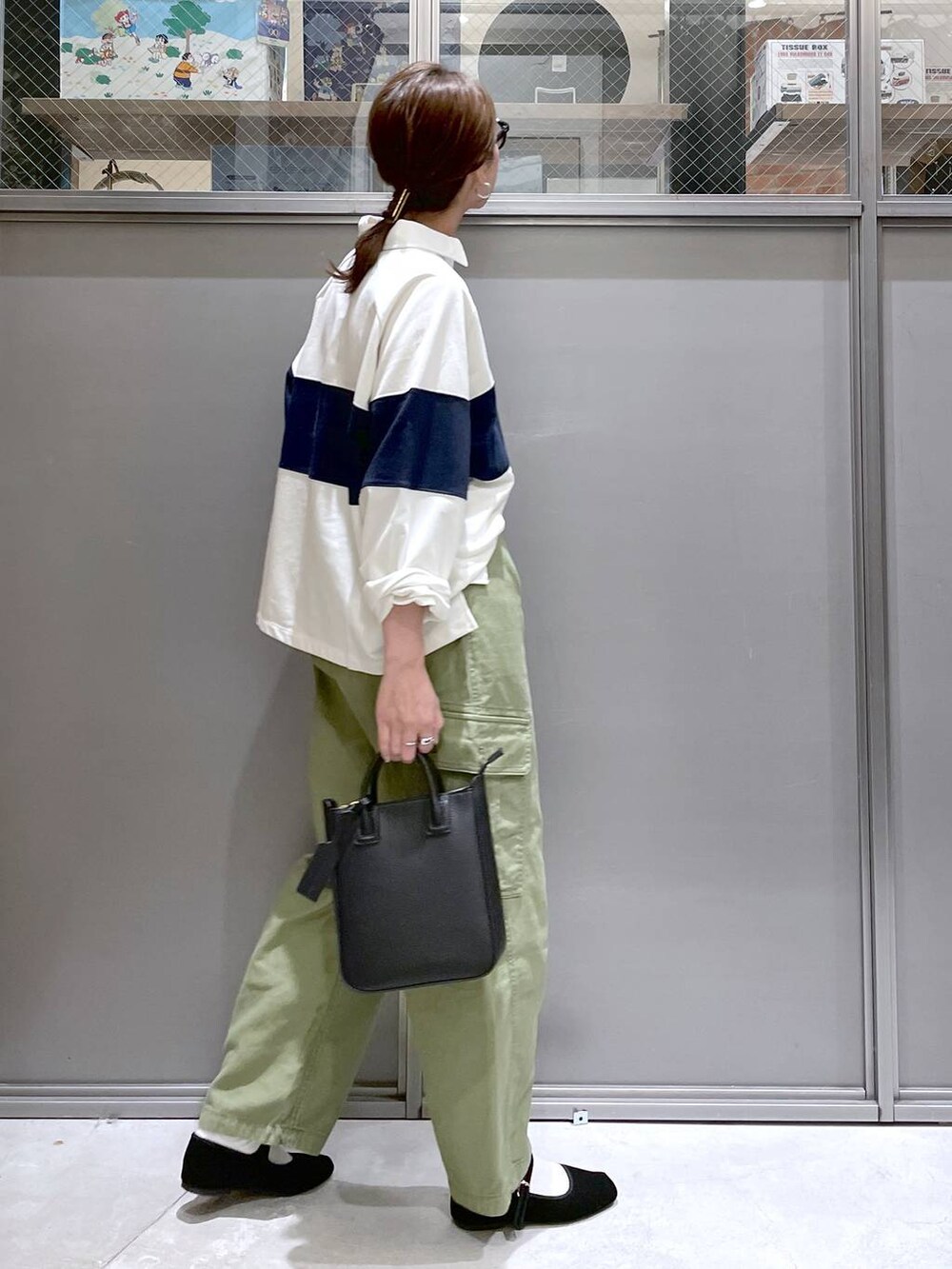 ブラック系のトートバッグ、ブラック系のパンプス、グリーン系のカーゴパンツを着用したレディースの春コーディネートの2枚目の写真