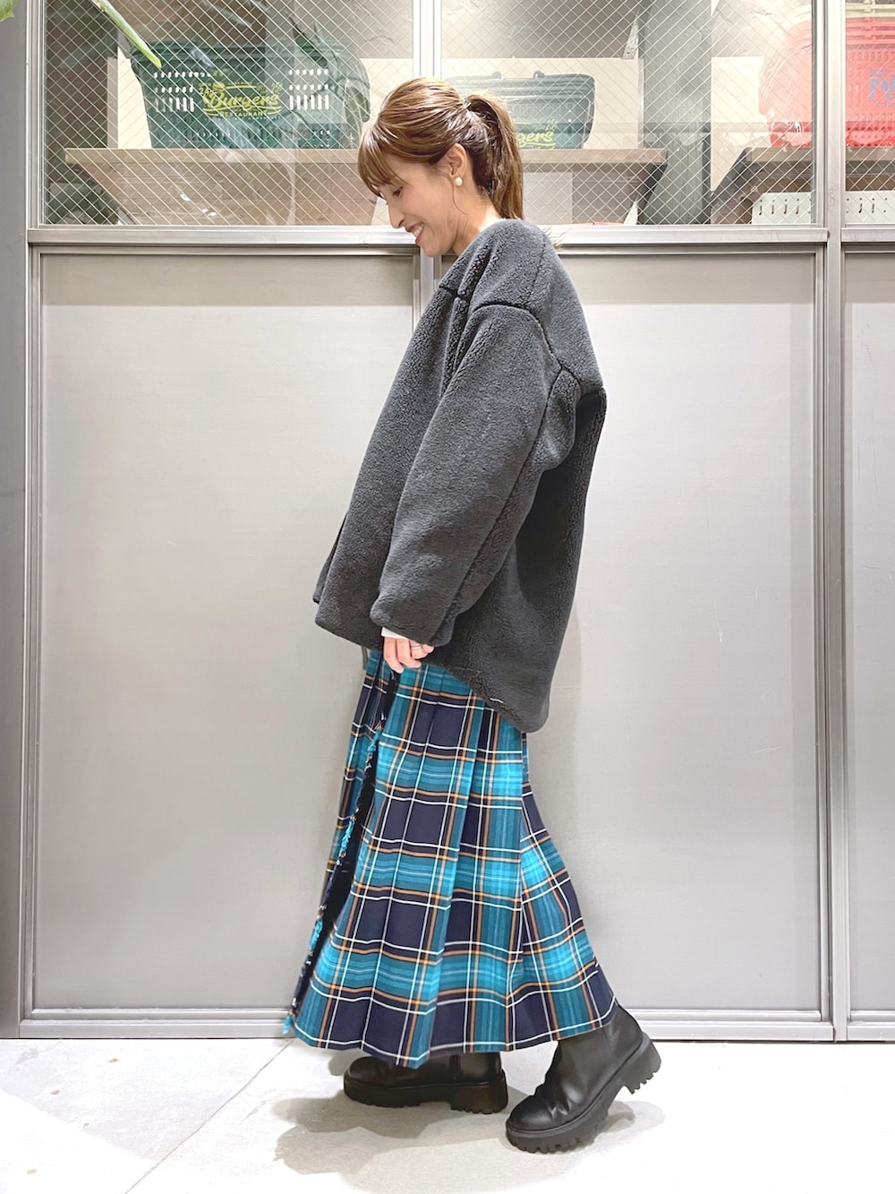 ベージュ系のニット/セーター、グレー系のブルゾン、ブルー系のスカートを着用したレディースの秋コーディネートの4枚目の写真