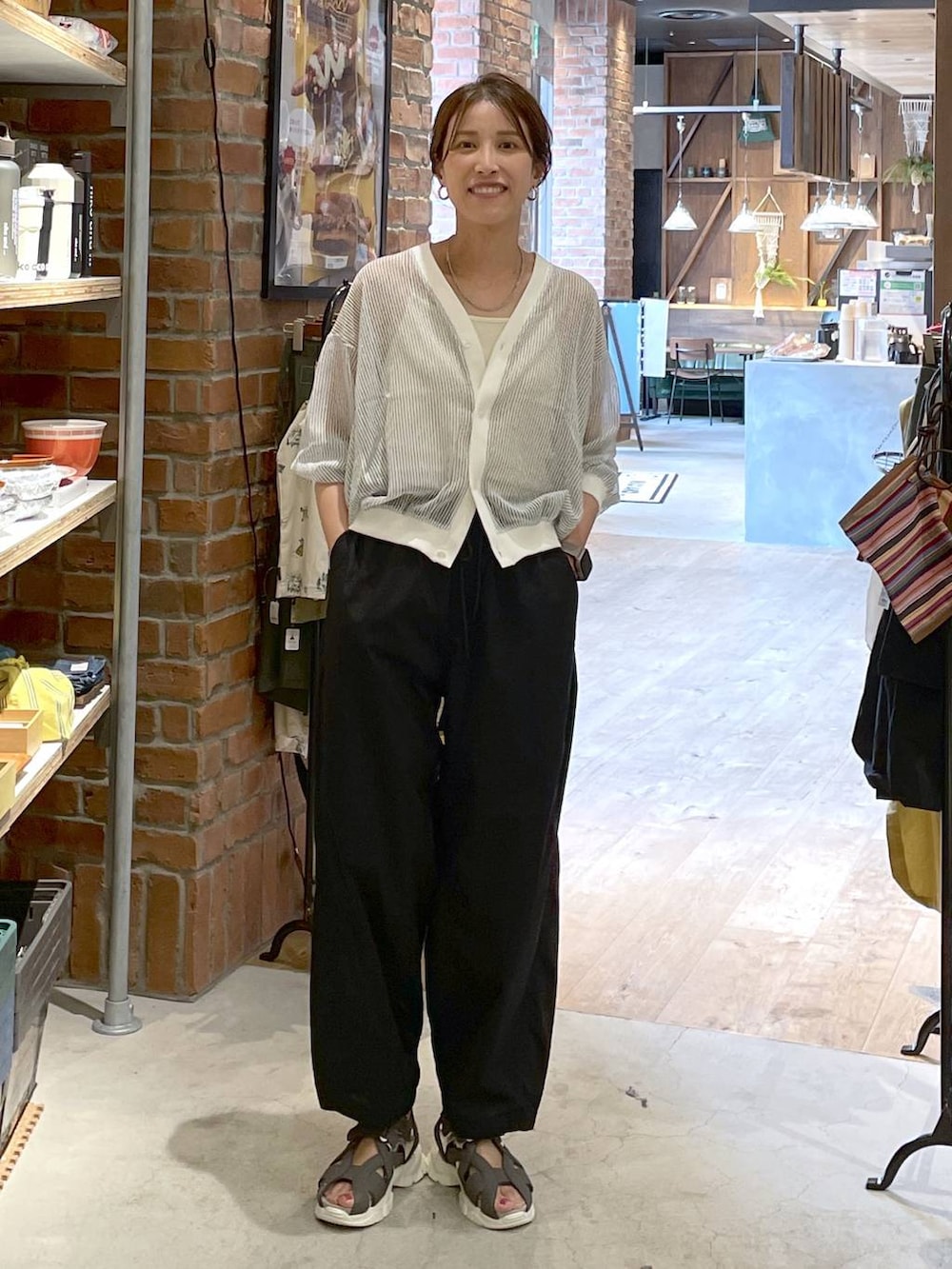 ホワイト系のカーディガン/ボレロ、ベージュ系のキャミソール、ブラック系のその他パンツを着用したレディースの夏コーディネートの9枚目の写真