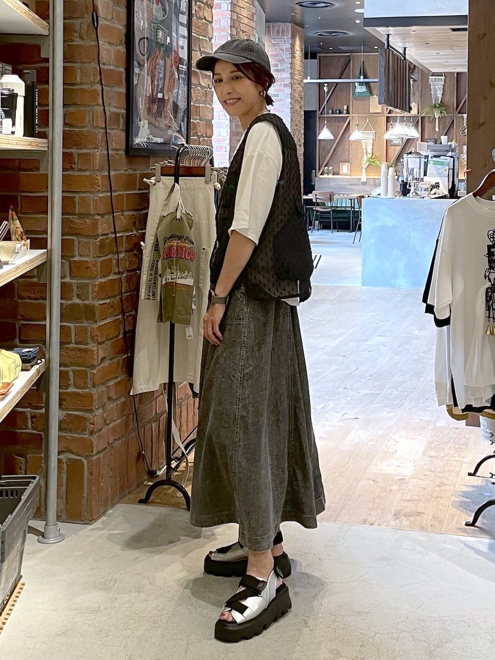 グレー系のサンダル、グレー系のスカート、ホワイト系のTシャツ/カットソーを着用したレディースの夏コーディネートの2枚目の写真