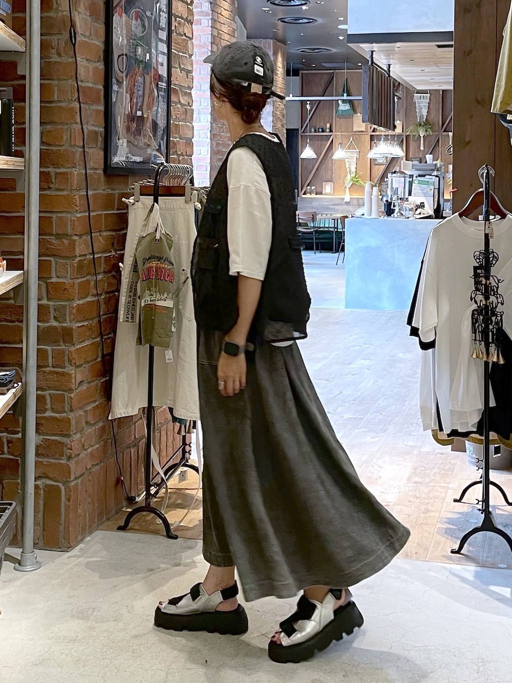 グレー系のサンダル、グレー系のスカート、ホワイト系のTシャツ/カットソーを着用したレディースの夏コーディネートの4枚目の写真