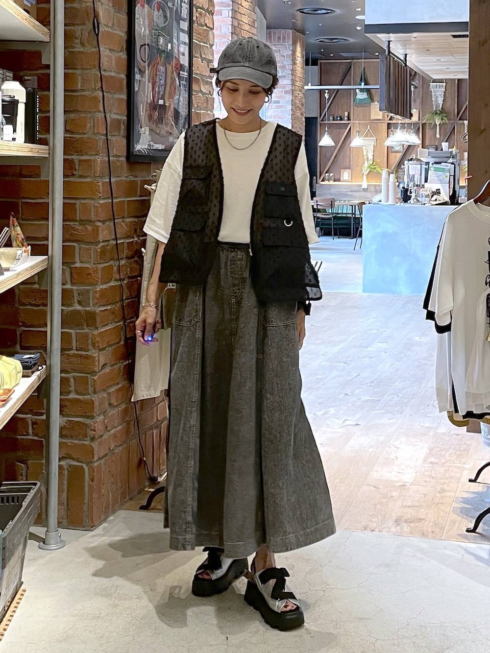 グレー系のサンダル、グレー系のスカート、ホワイト系のTシャツ/カットソーを着用したレディースの夏コーディネートの7枚目の写真