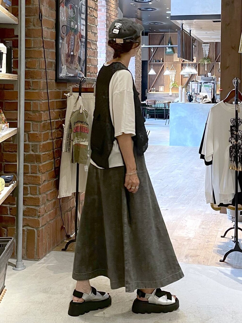 グレー系のサンダル、グレー系のスカート、ホワイト系のTシャツ/カットソーを着用したレディースの夏コーディネートの6枚目の写真