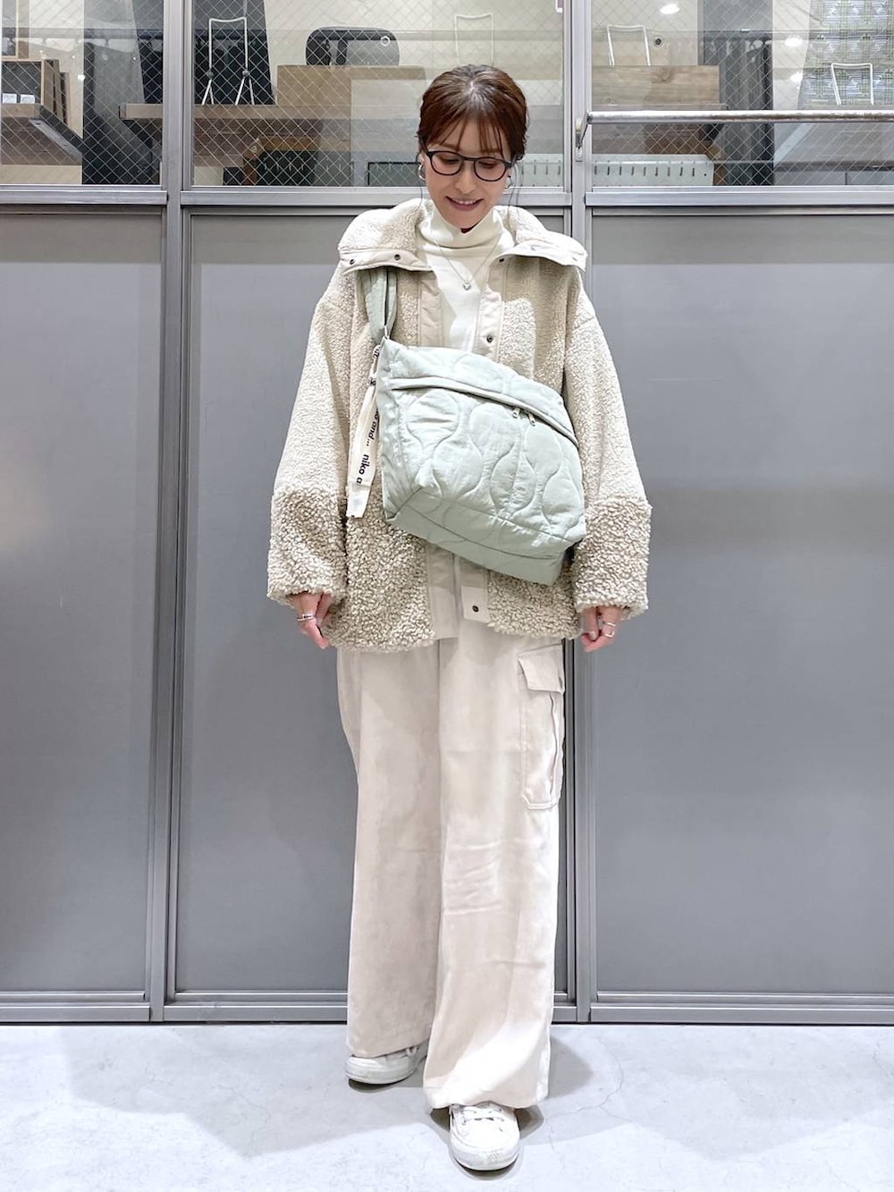 ベージュ系のその他アウター、ベージュ系のニット/セーター、グリーン系のショルダーバッグを着用したレディースの秋コーディネートの5枚目の写真