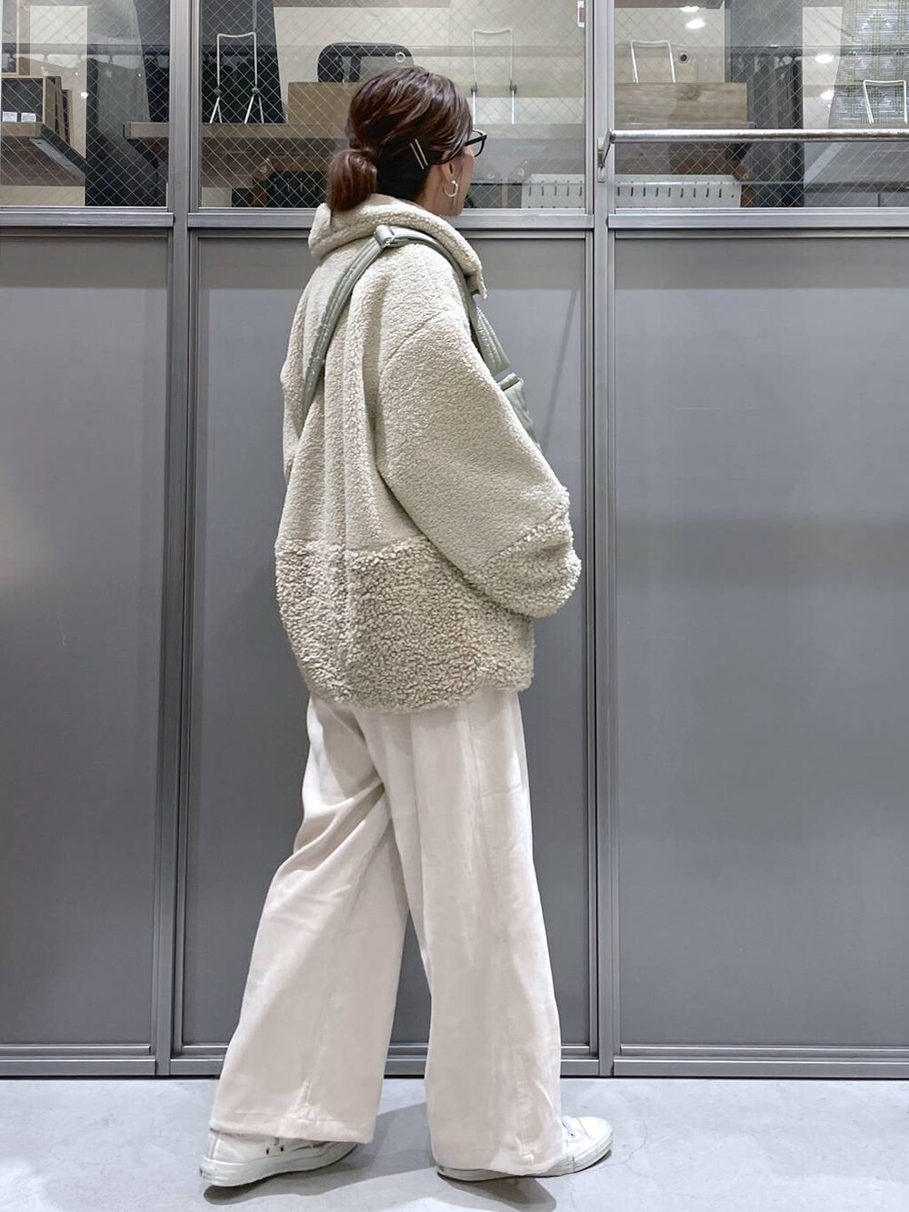 ベージュ系のその他アウター、ベージュ系のニット/セーター、グリーン系のショルダーバッグを着用したレディースの秋コーディネートの2枚目の写真