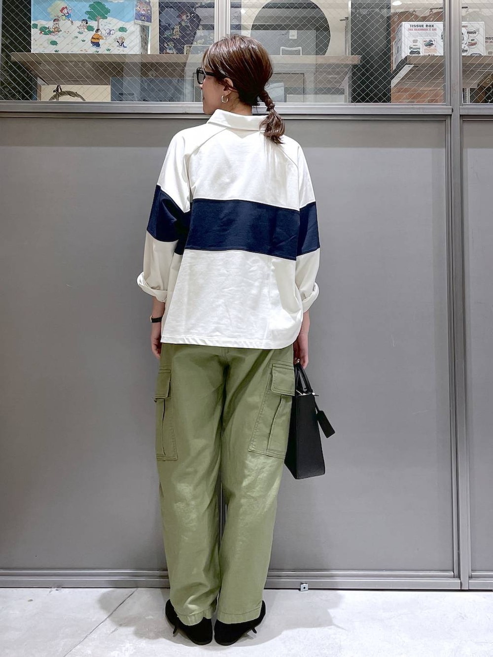 ブラック系のトートバッグ、ブラック系のパンプス、グリーン系のカーゴパンツを着用したレディースの春コーディネートの3枚目の写真