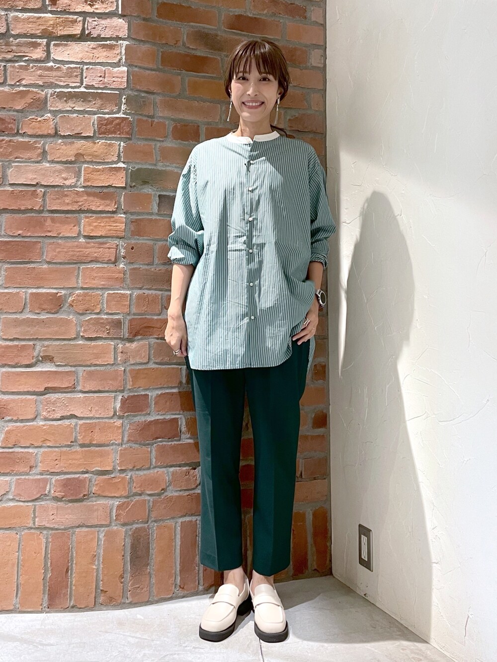 グリーン系のシャツ/ブラウス、グリーン系のその他パンツ、ベージュ系のローファーを着用したレディースの夏コーディネートの5枚目の写真