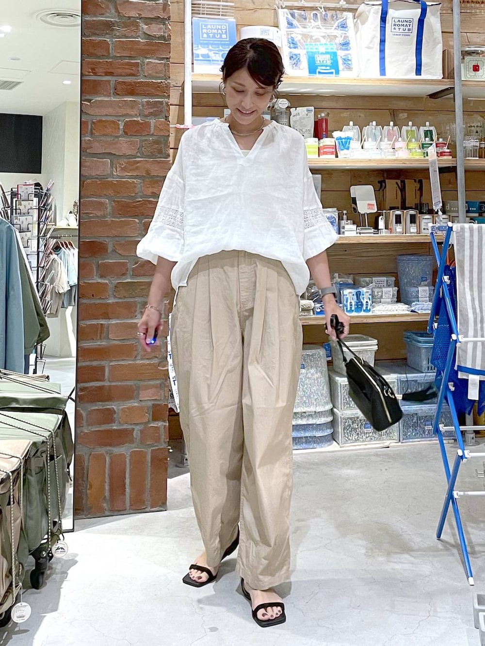 ブラック系のサンダル、ブラック系のショルダーバッグ、ベージュ系のキャミソールを着用したレディースの夏コーディネートの8枚目の写真