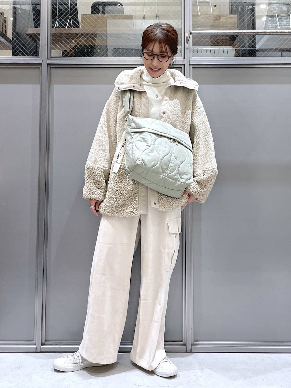 ベージュ系のその他アウター、ベージュ系のニット/セーター、グリーン系のショルダーバッグを着用したレディースの秋コーディネートの6枚目の写真