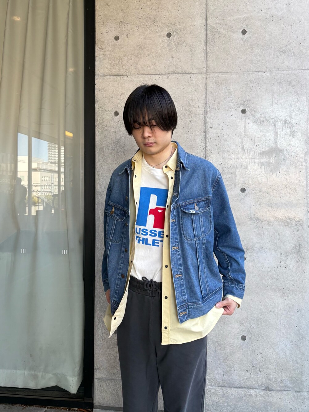 ブルー系のデニムジャケット、イエロー系のシャツ/ブラウス、ホワイト系のTシャツ/カットソーを着用したメンズの春コーディネートの3枚目の写真
