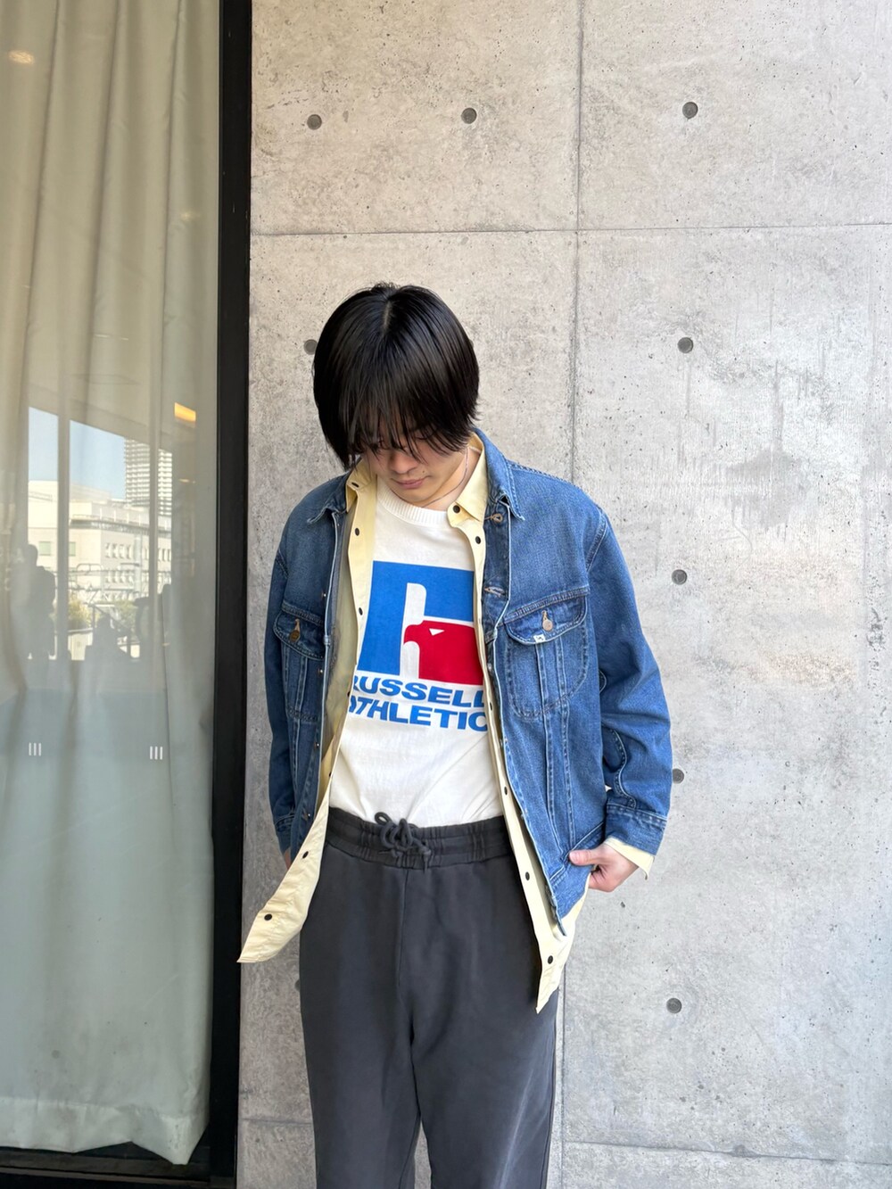 ブルー系のデニムジャケット、イエロー系のシャツ/ブラウス、ホワイト系のTシャツ/カットソーを着用したメンズの春コーディネートの4枚目の写真