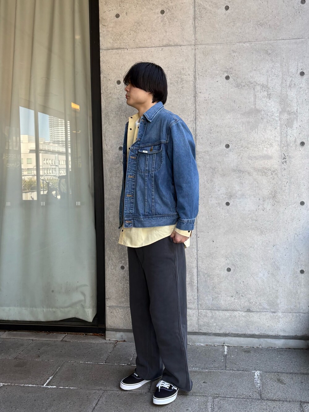 ブルー系のデニムジャケット、イエロー系のシャツ/ブラウス、ホワイト系のTシャツ/カットソーを着用したメンズの春コーディネートの2枚目の写真
